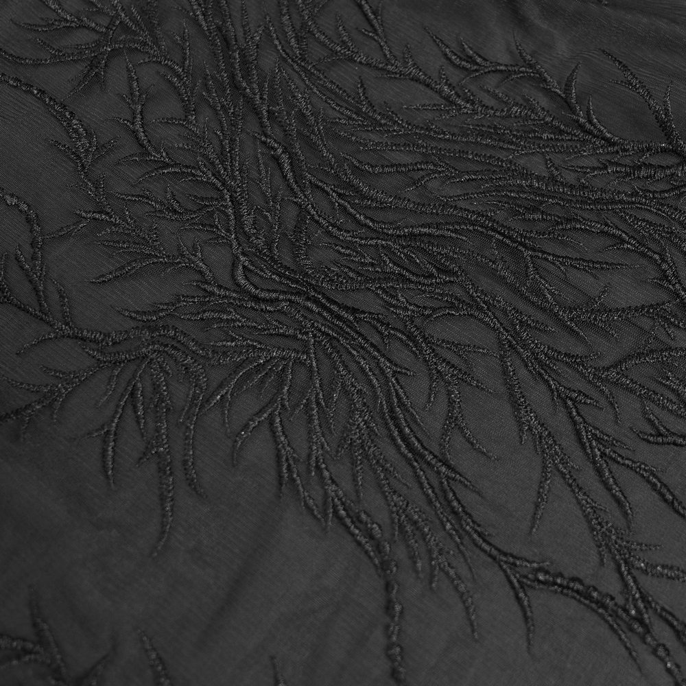 Close-up of elegant black lace fabric with intricate floral embroidery detailing for gothic fashion.