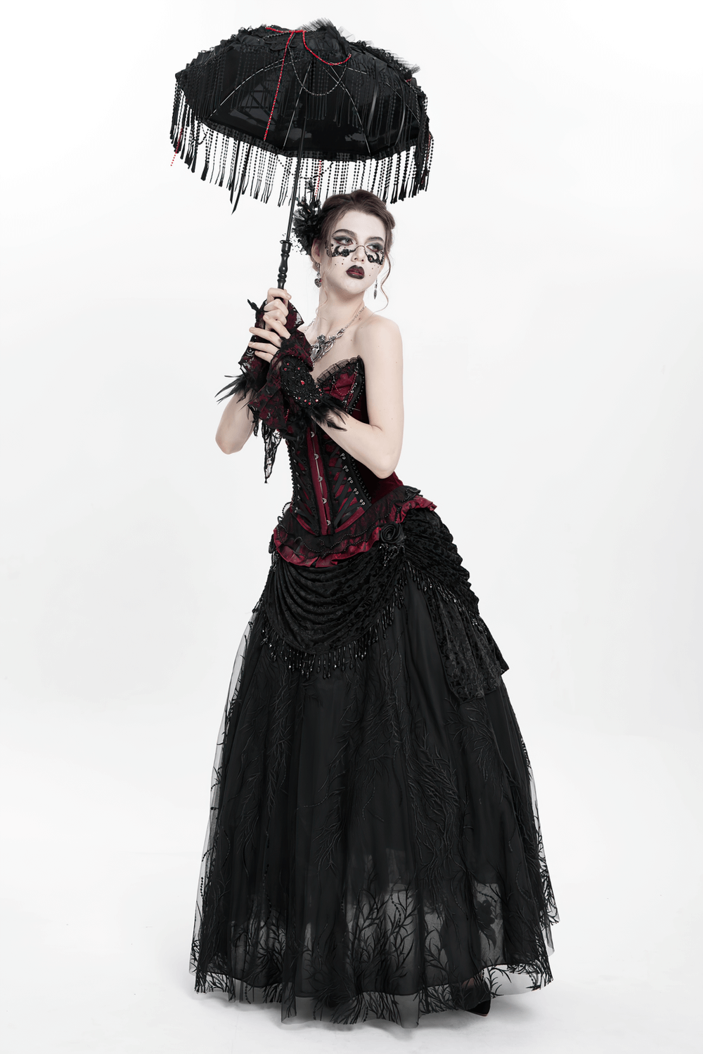 Elegant model in a Victorian gothic outfit, holding a fringed parasol and wearing a dramatic black lace skirt.