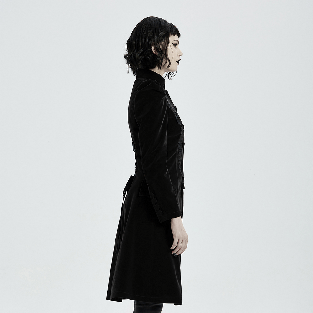 Side view of a woman in an elegant black velvet lace-up trench coat, showcasing Gothic style and chic silhouette.