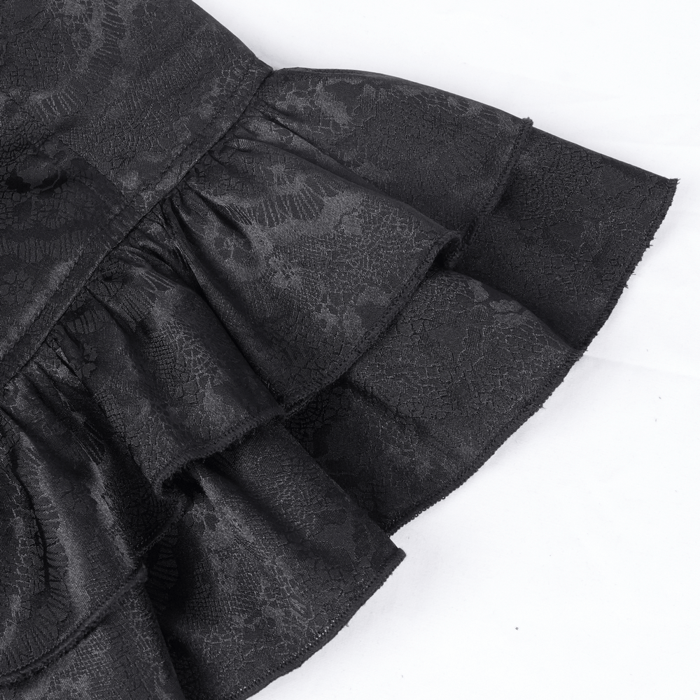 Close-up of a black gothic blouse's ruffled lace hem, showcasing intricate patterns and elegant texture.