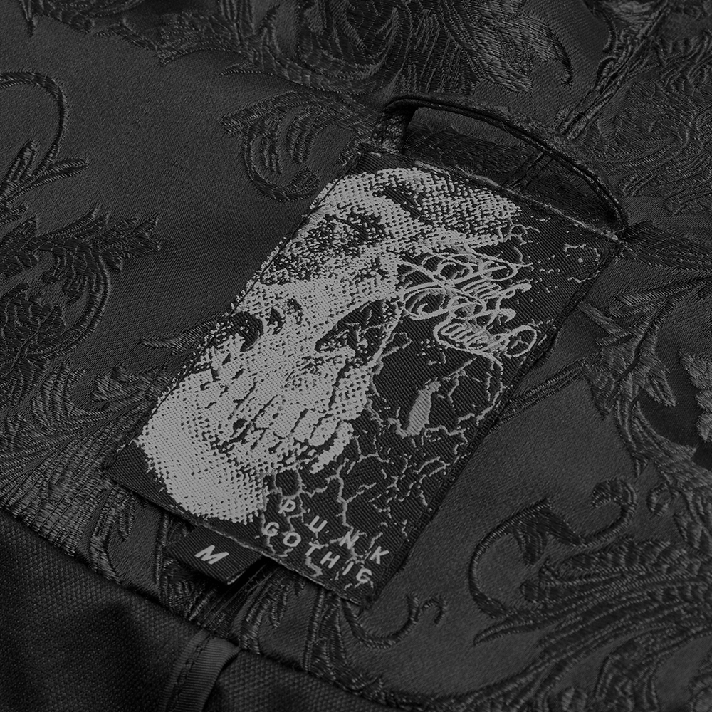 Detailed close-up of a Gothic cloak's tag featuring a skull design and intricate jacquard texture.