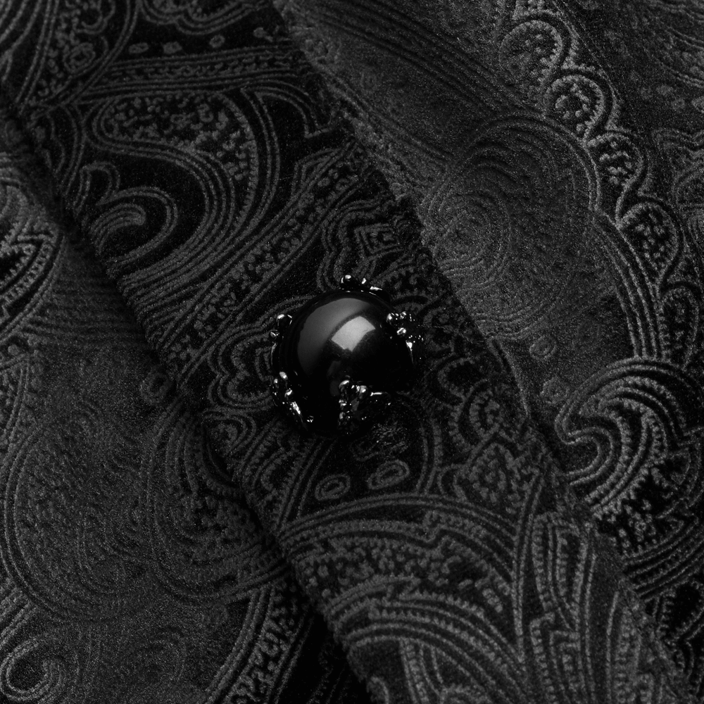 Close-up of black Gothic fabric with an elegant gemstone button, showcasing dark elegance and intricate patterns.