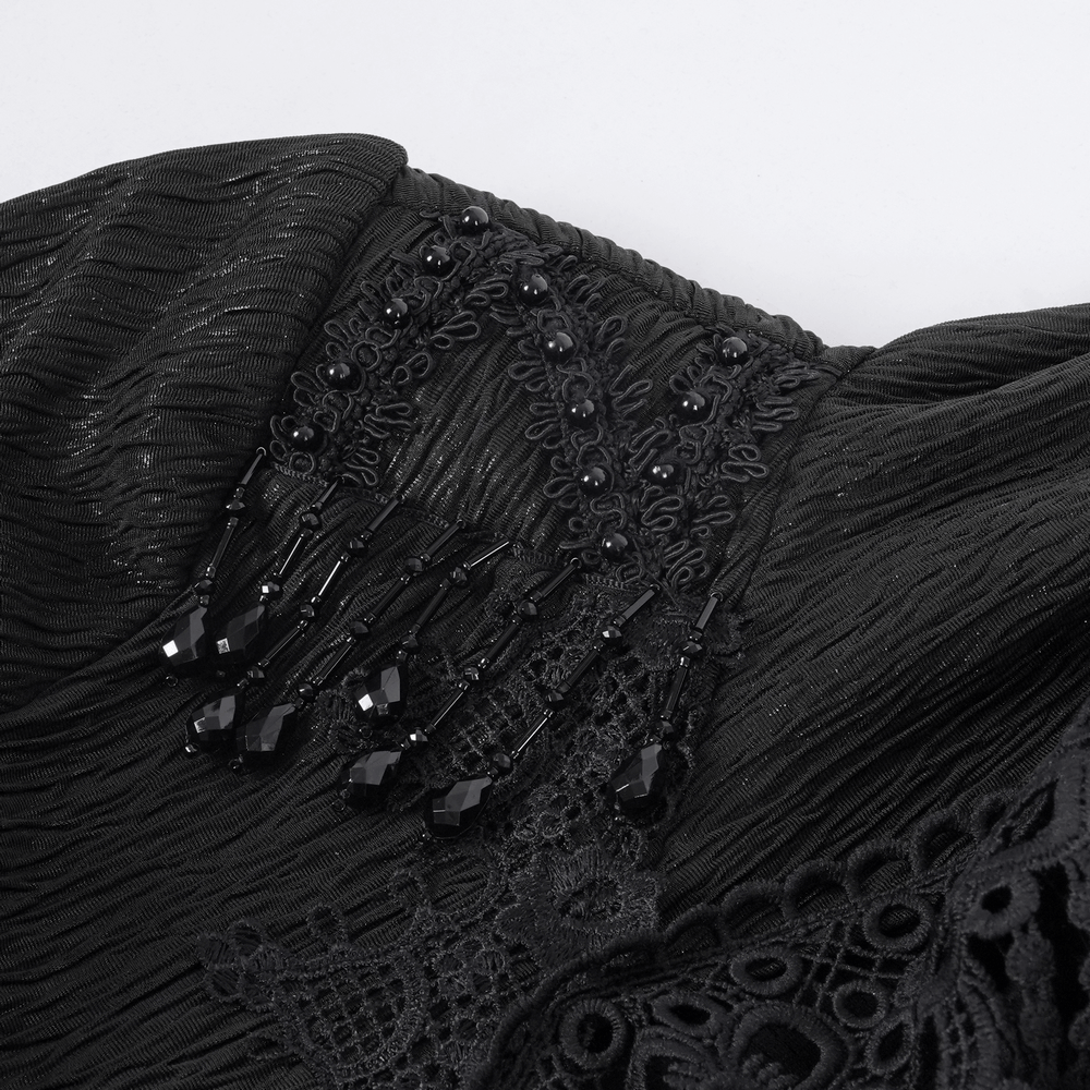 Close-up of black lace and bead detailing on an elegant Gothic hooded cape.