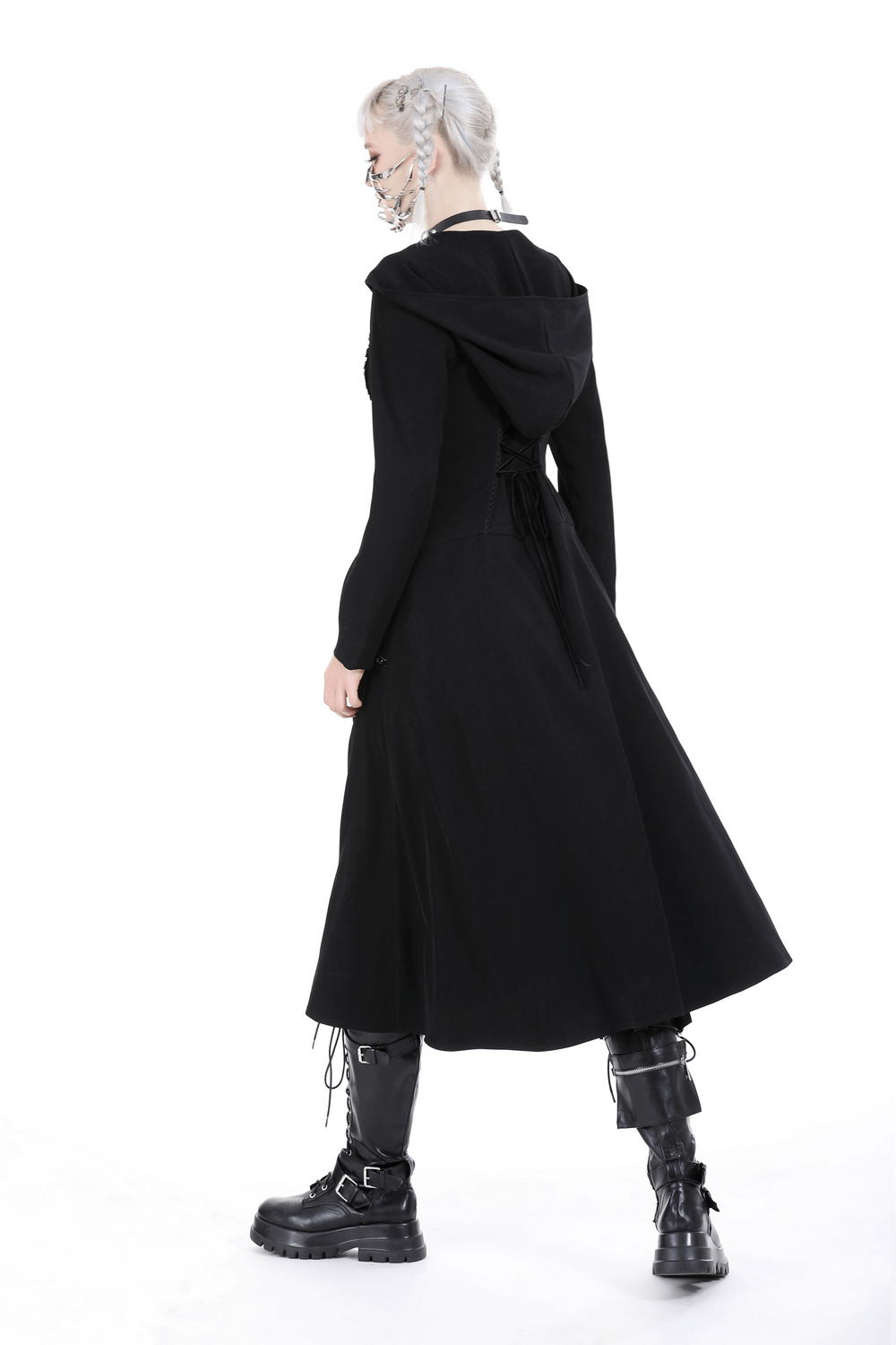 Back view of an elegant black hooded gothic trench coat with lace detailing, paired with trendy combat boots.