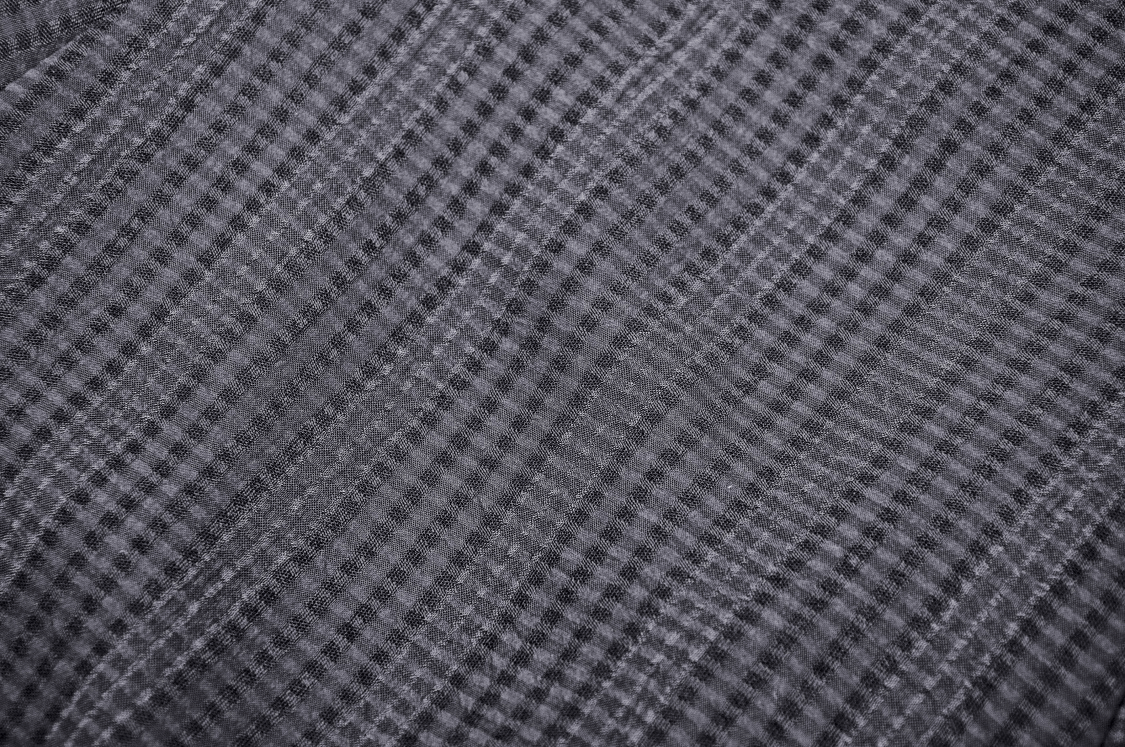 Close-up of textured black and gray plaid fabric, perfect for gothic fashion and elegant attire.