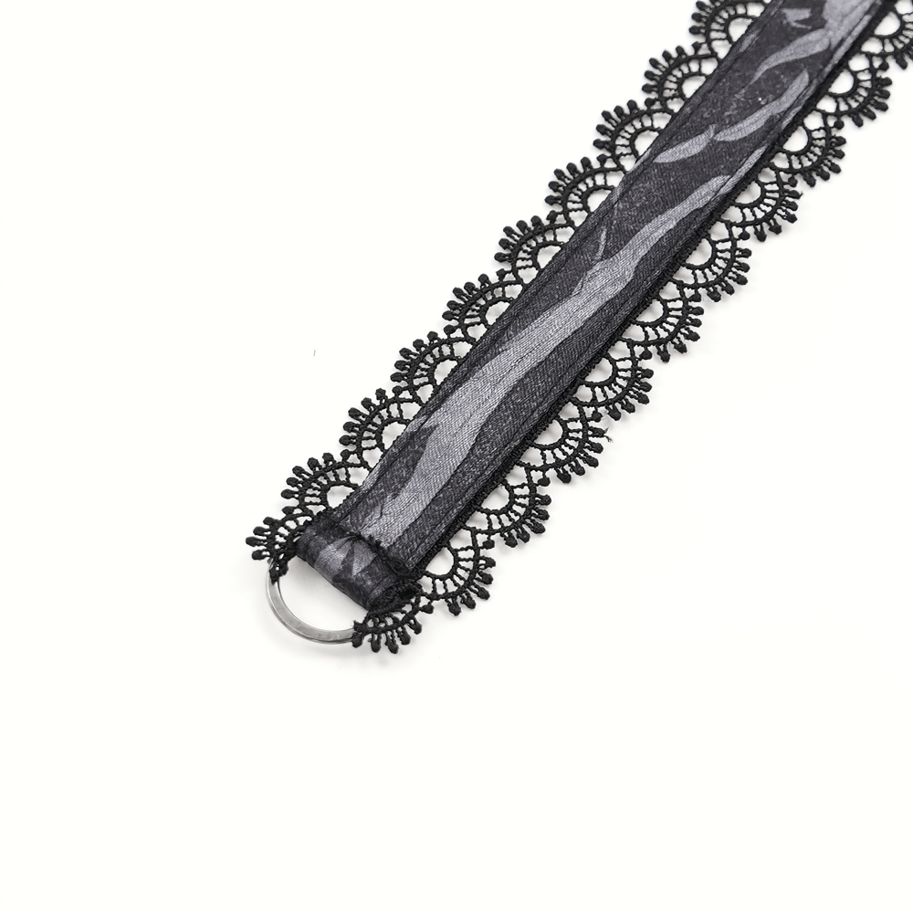 Close-up of intricate black lace trim with decorative patterns and a metal ring, ideal for gothic corsets and accessories.