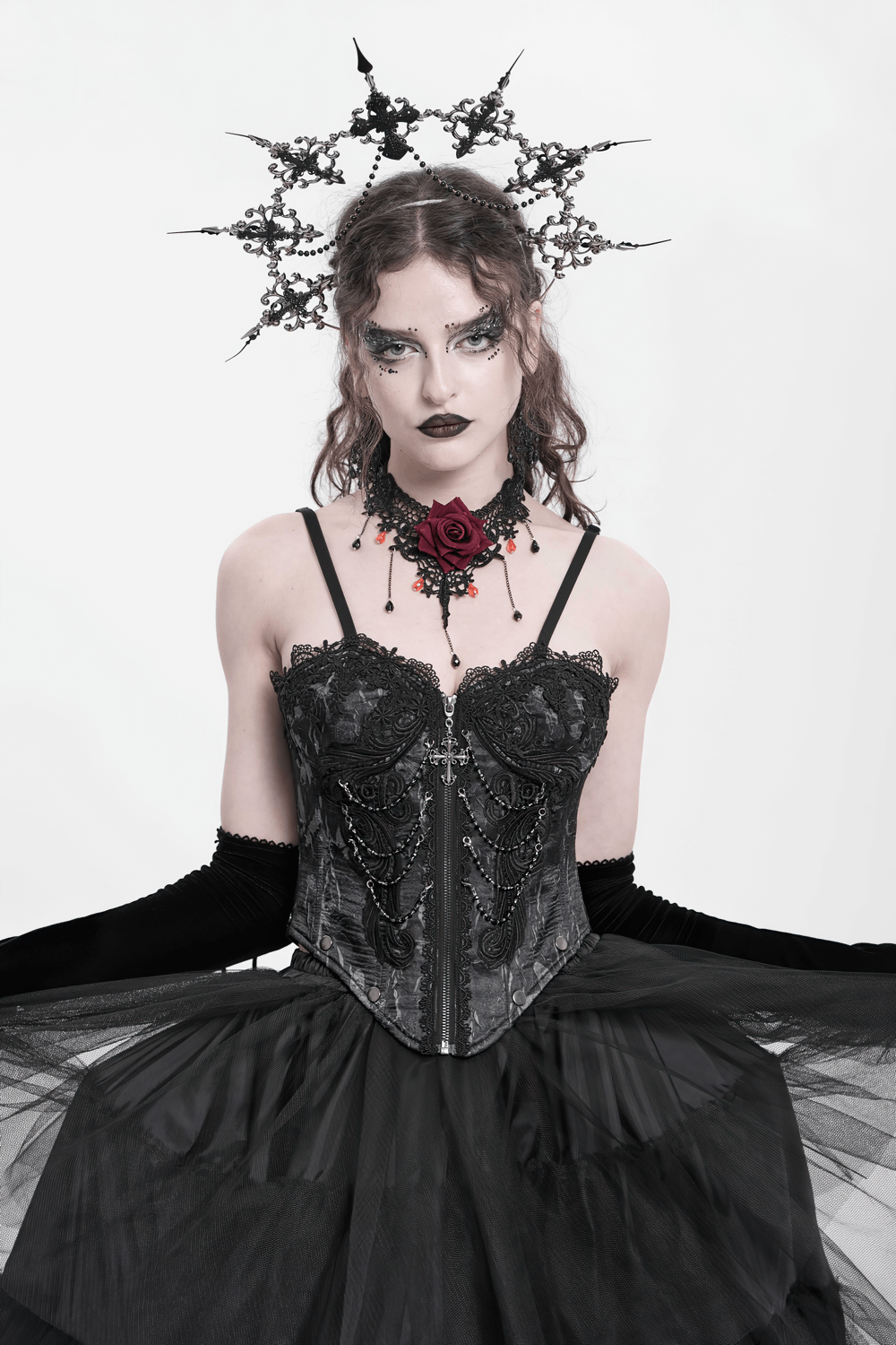 Elegant gothic corset with chains and lace trim, styled with dramatic accessories and a tulle skirt.