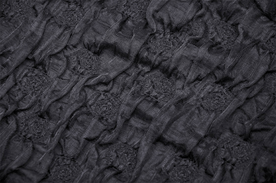 Black lace fabric showcasing intricate rose lace trim and crinkle texture, perfect for gothic or romantic styles.