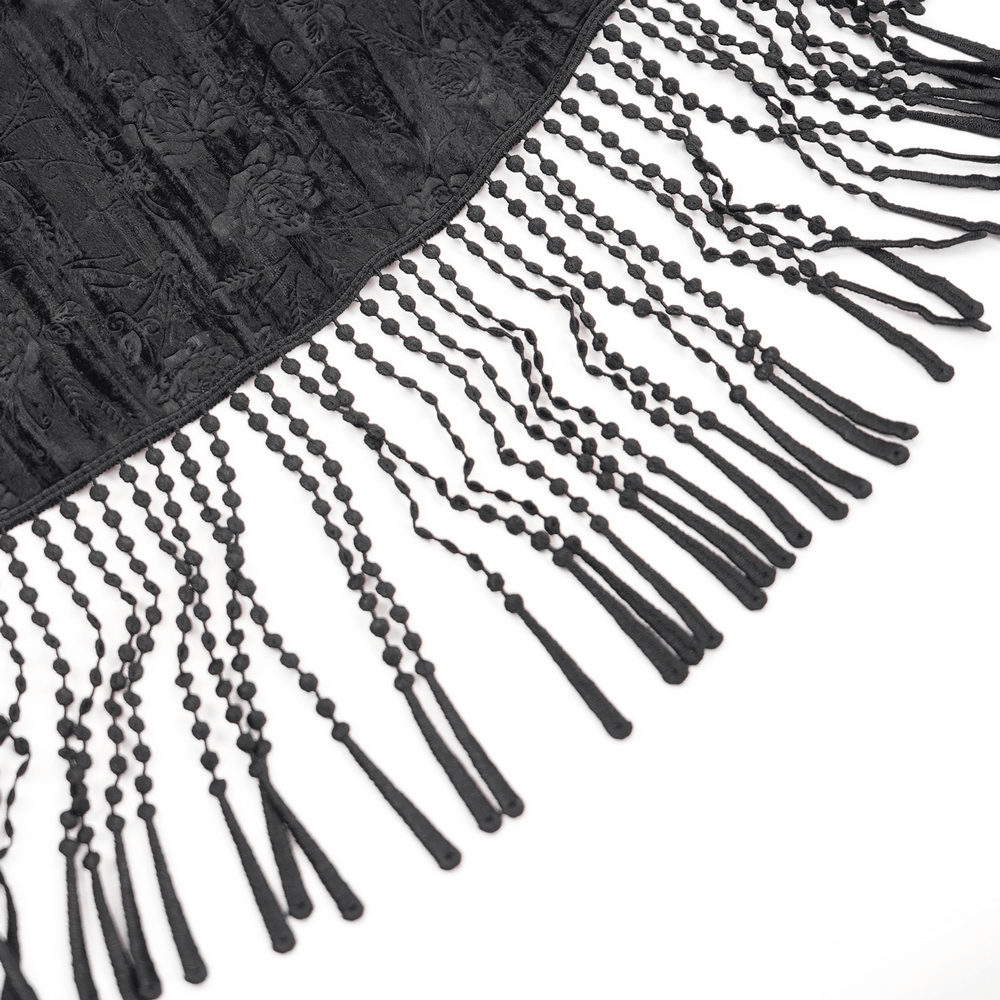 Close-up of black lace skirt hem featuring elegant tassel details and intricate floral embroidery.