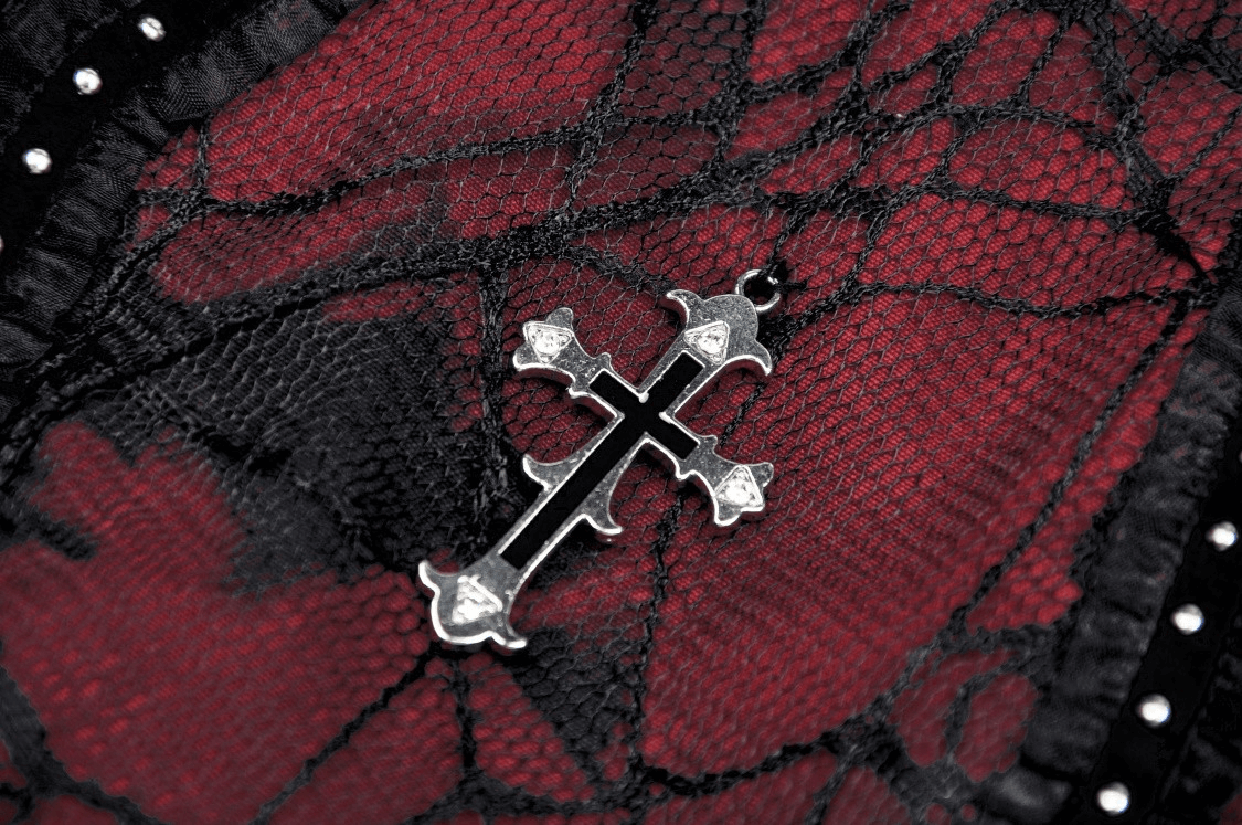 Close-up of gothic black and wine red lace with a silver cross detail showcasing elegance in design.