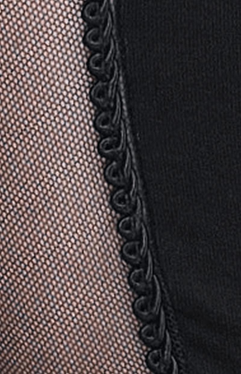 Close-up of elegant black leggings featuring transparent mesh panels and baroque detailing for a gothic style.