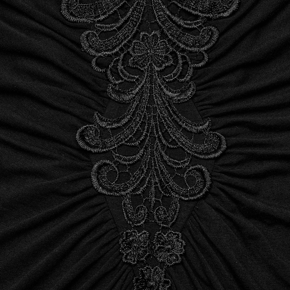 Close-up of intricate black lace detailing on an elegant gothic dress, showcasing delicate embroidery and texture.