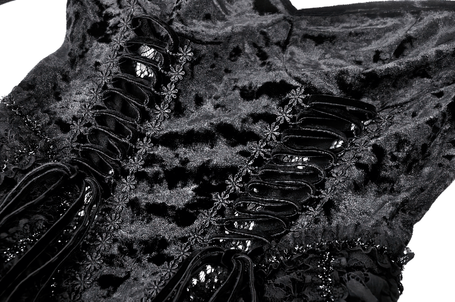 Close-up of elegant black velvet dress with lace details and eye-catching corset ties.