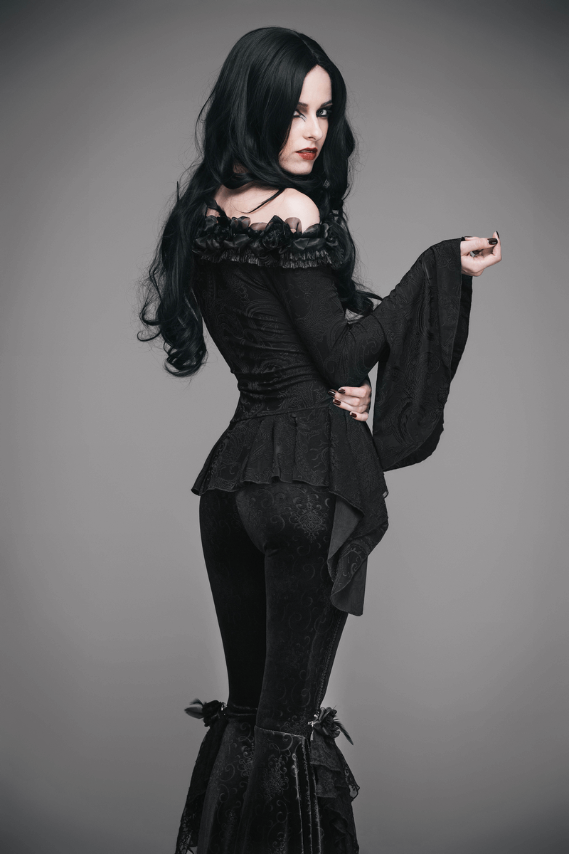 Elegant gothic black top with romantic flared sleeves and lace-up details, showcasing a stylish model in a striking pose.