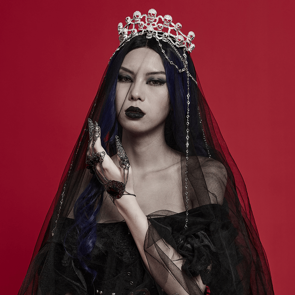 Elegant Gothic Skull Tiara adorned with chains, worn by a model in a black veil against a bold red background.