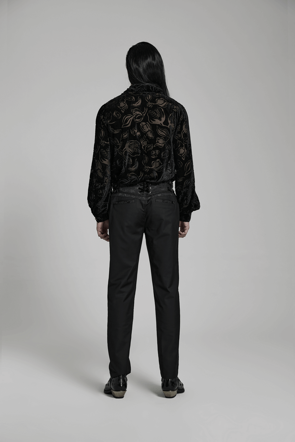 Back view of a model in elegant Gothic slim-fit black jacquard pants and a floral velvet shirt.