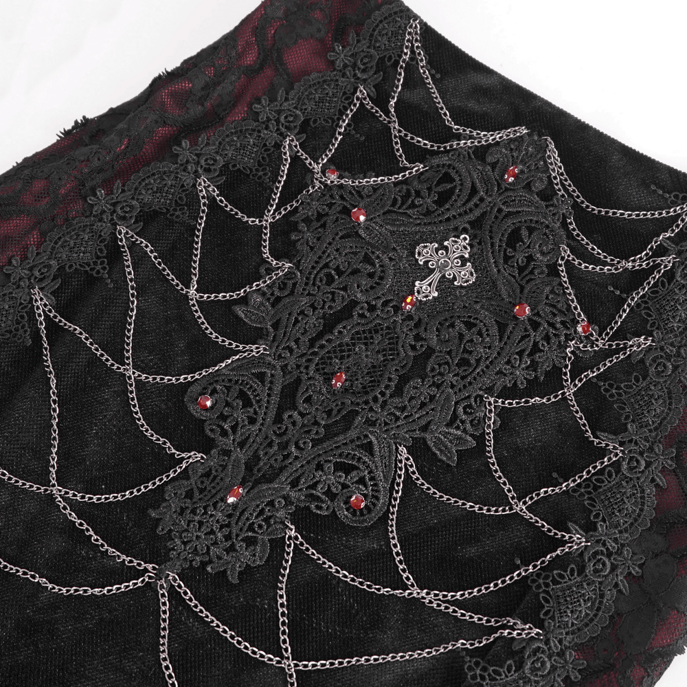 Close-up of black lace and velvet mermaid skirt with intricate spider web design and red embellishments.