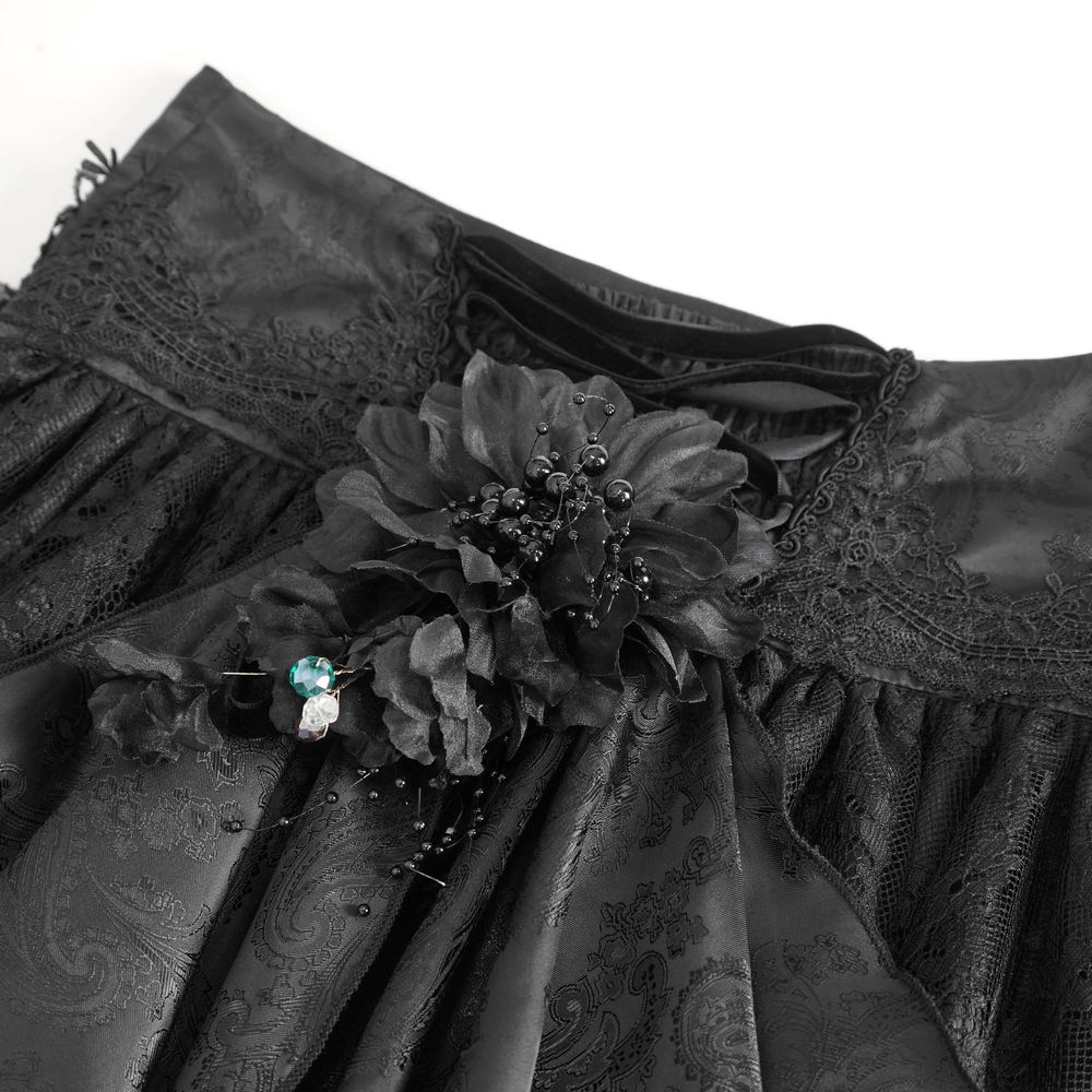 Close-up of elegant Gothic Victorian lace skirt detail featuring ruffles and floral embellishments in black.