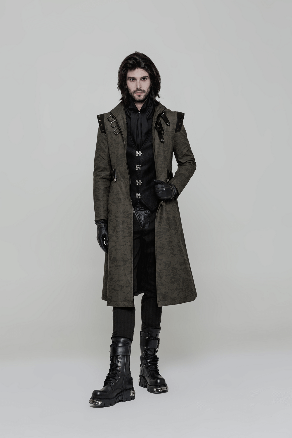 Man in elegant gothic Victorian waistcoat and long coat, showcasing steampunk fashion with boots and stylish accessories.