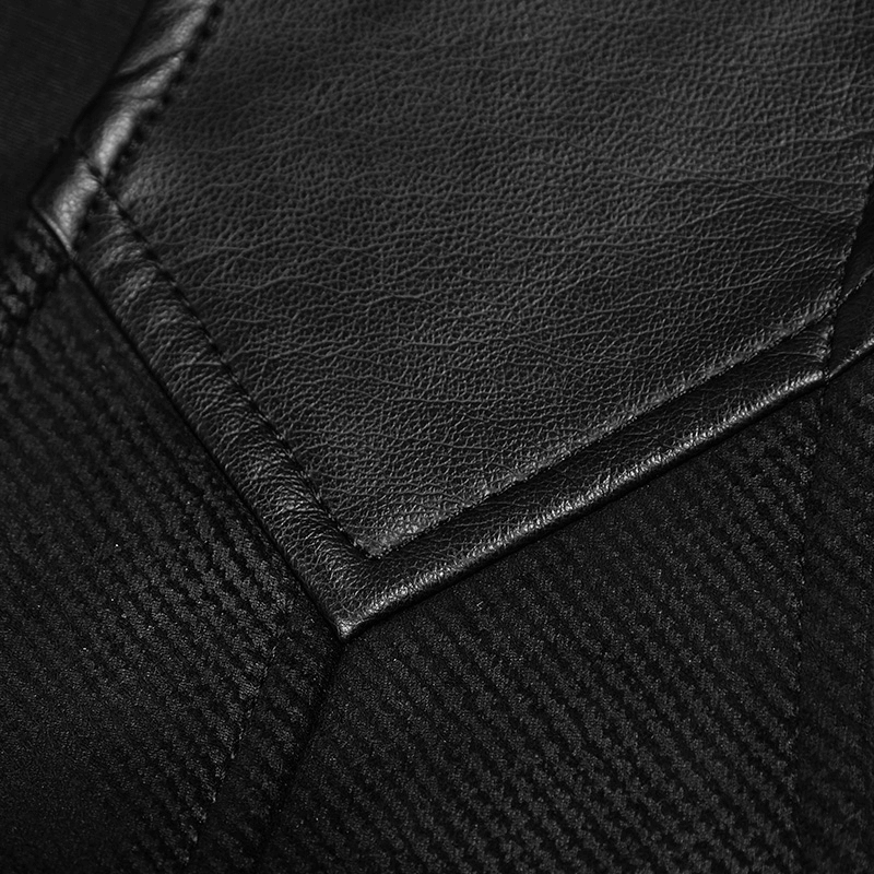 Close-up of the elegant black fabric texture and leather detail on a gothic Victorian waistcoat.