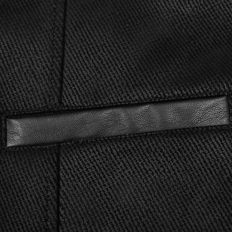Close-up of the elegant fabric detail on a gothic Victorian waistcoat with sleek black texture.