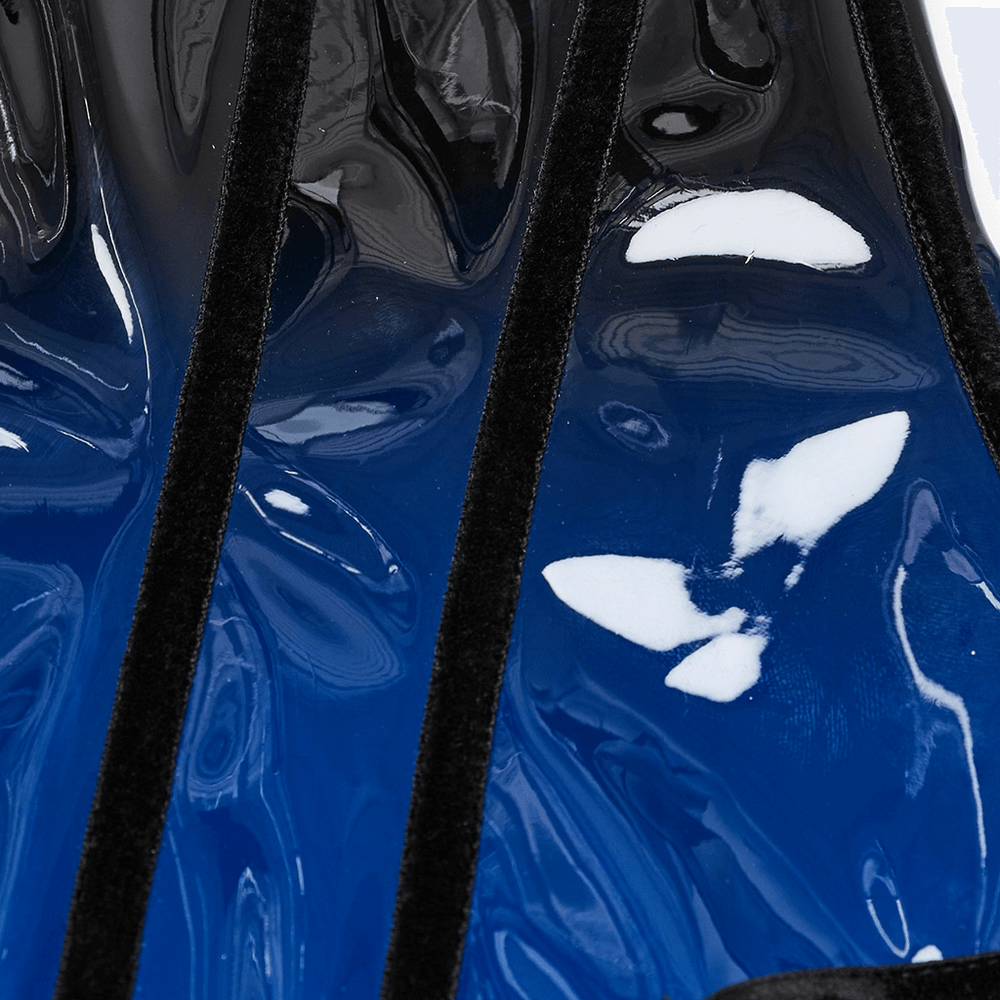 Close-up of elegant gradient patent leather corset showcasing glossy blue-black finish and decorative design accents.