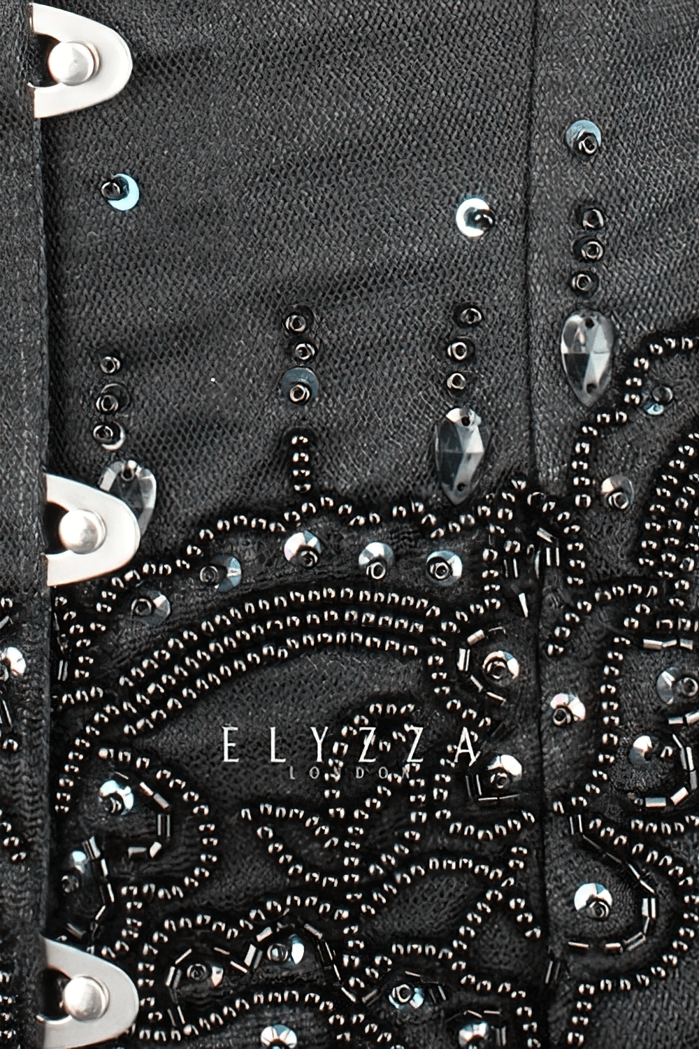 Close-up of elegant black waist training corset with intricate beadwork and lace detailing for women.