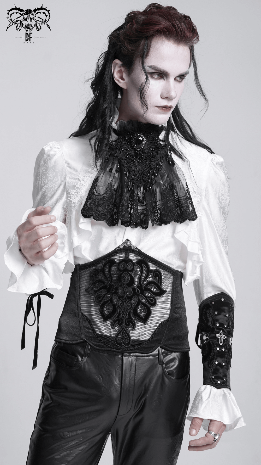 Stylish male model wearing a black lace corset belt and elegant Gothic attire with intricate details and ruffles.