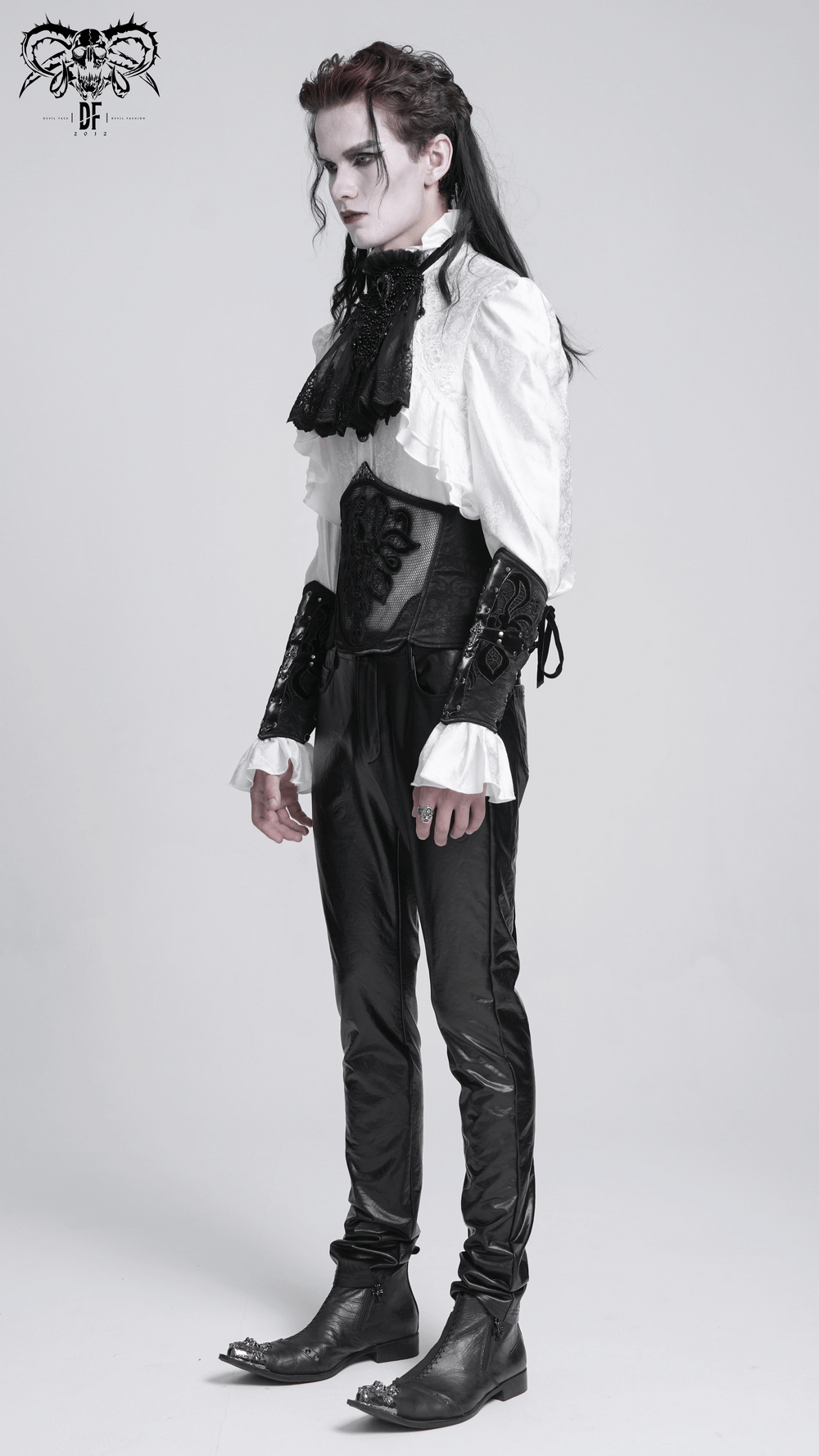 Chic gothic model wearing a white ruffled shirt and black corset belt, showcasing an elegant and edgy style.