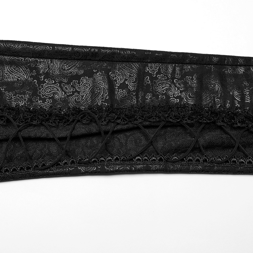 Close-up of elegant black leggings featuring intricate lace and shimmering patterned design.