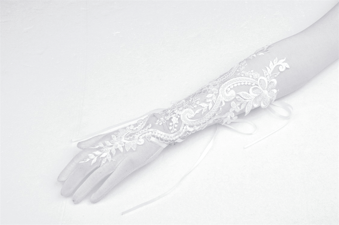 Elegant lace bridal gloves with floral embroidery, perfect for adding sophistication to any wedding attire.