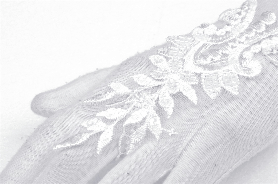 Elegant lace bridal gloves featuring intricate floral embroidery for a chic wedding look.