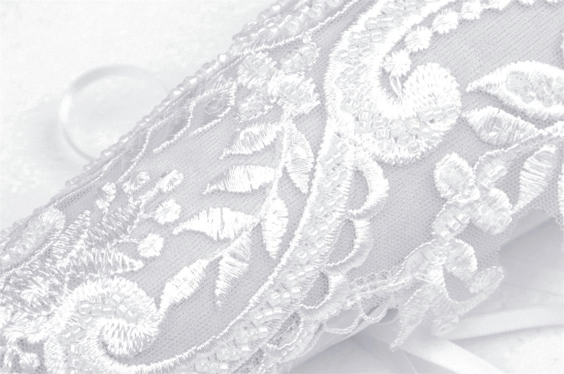 Elegant lace bridal gloves featuring intricate floral embroidery on delicate fabric.
