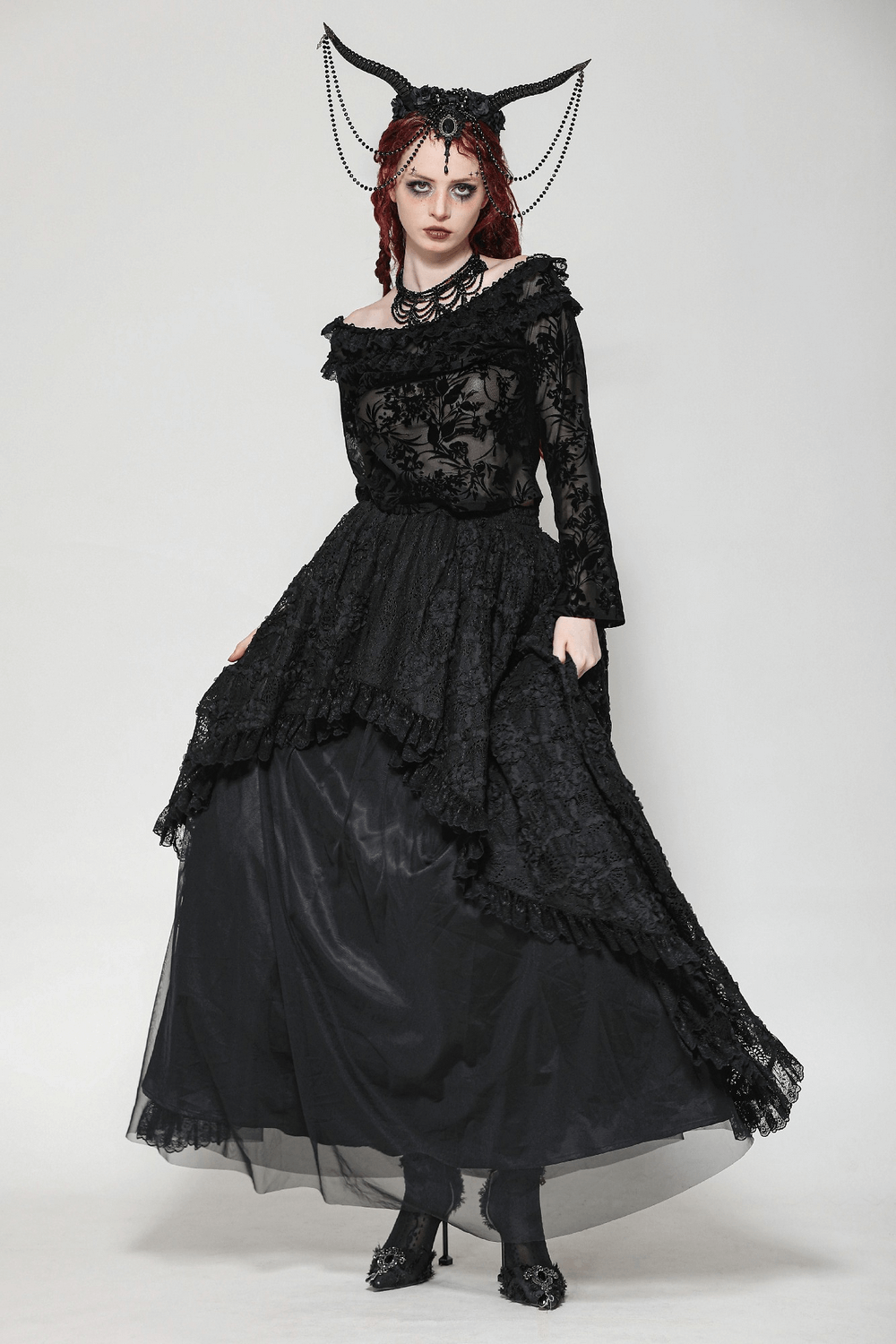 Model wearing an elegant black lace floral Bardot top and dramatic layered skirt, showcasing gothic romantic style.