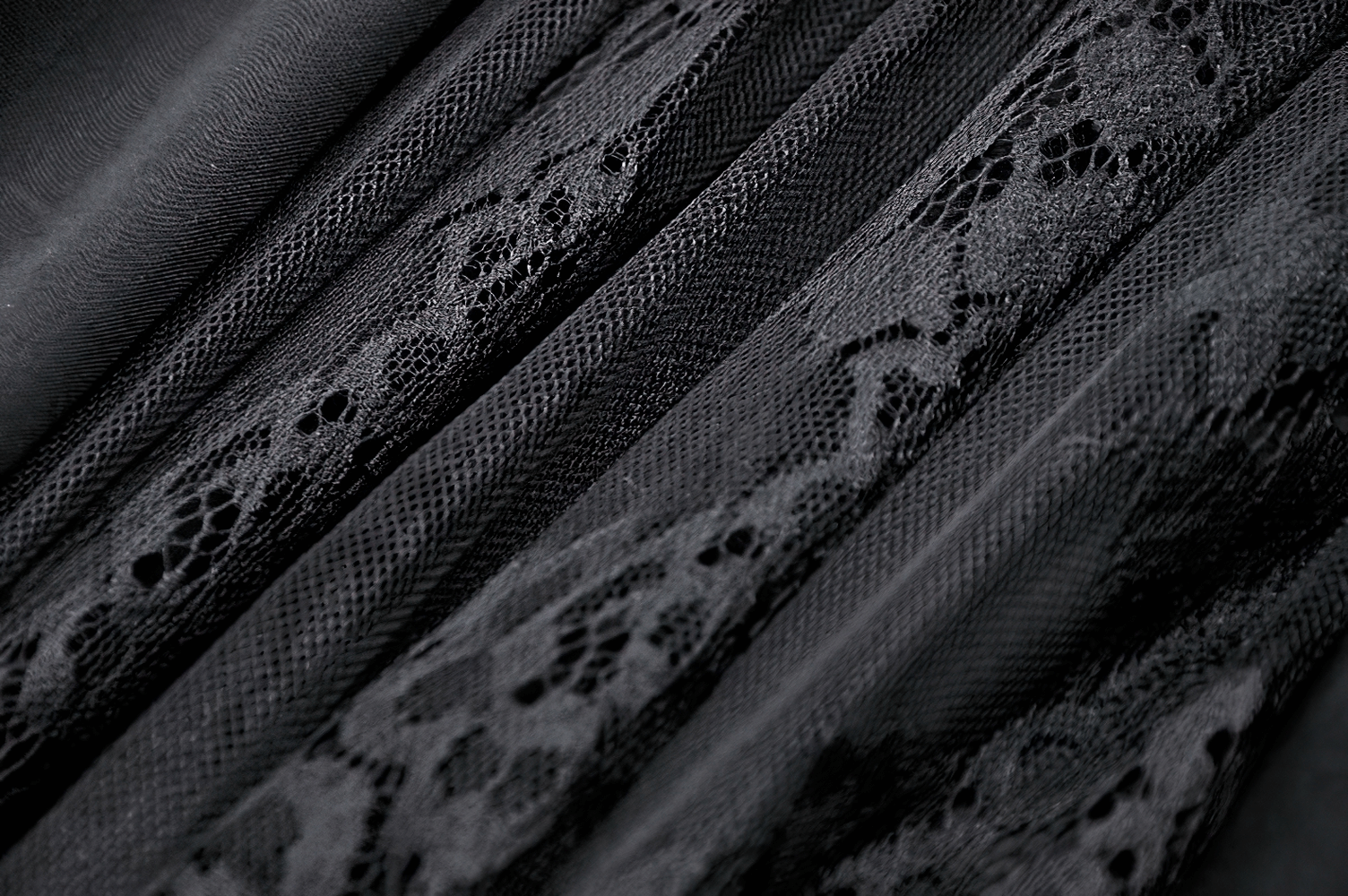 Close-up of luxurious black lace fabric with intricate patterns, perfect for a gothic high-waist maxi skirt.