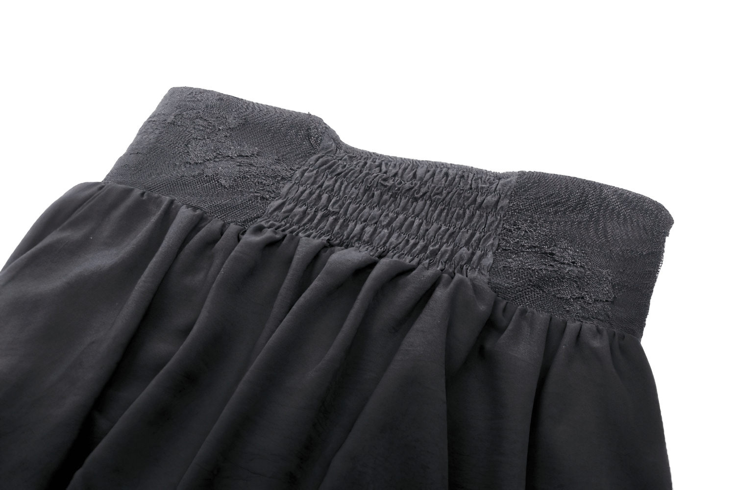 Close-up of the smocked waistband and lace detail of an elegant black high waist skirt.