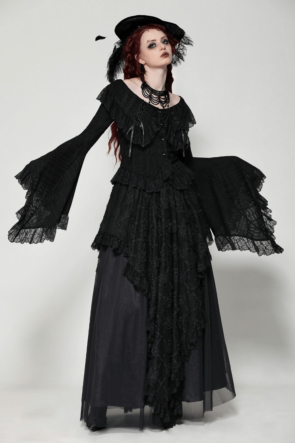 Elegant model in a black lace layered maxi skirt and dramatic bell-sleeve top, showcasing gothic style and sophistication.