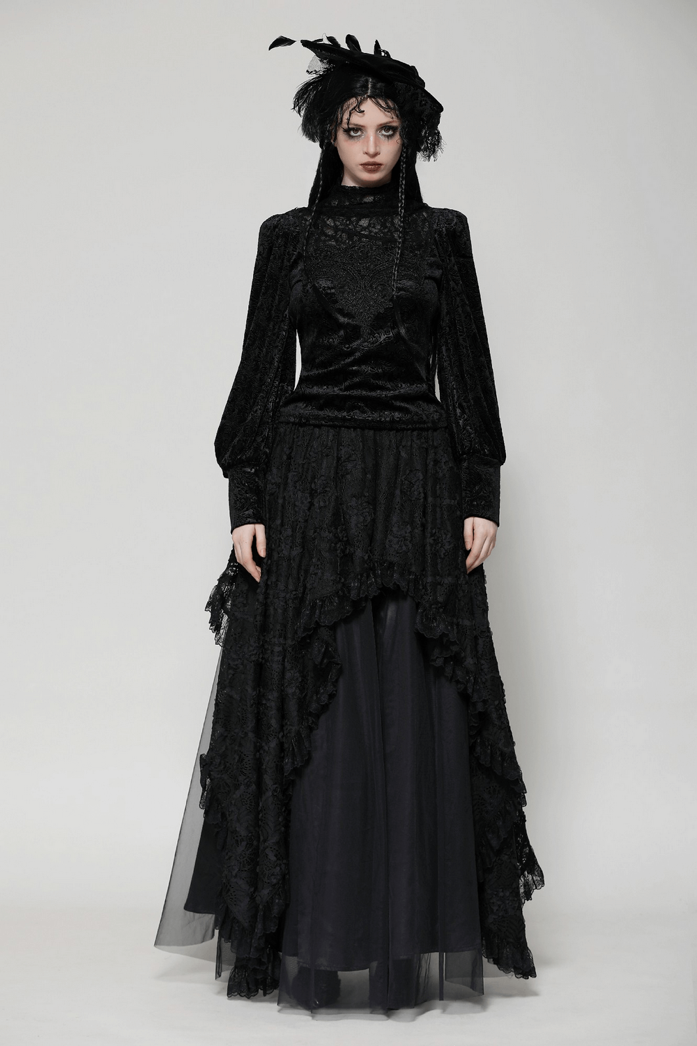 Elegant gothic woman in black lace layered maxi skirt and long-sleeve top, styled with feathered headpiece and dramatic silhouette.