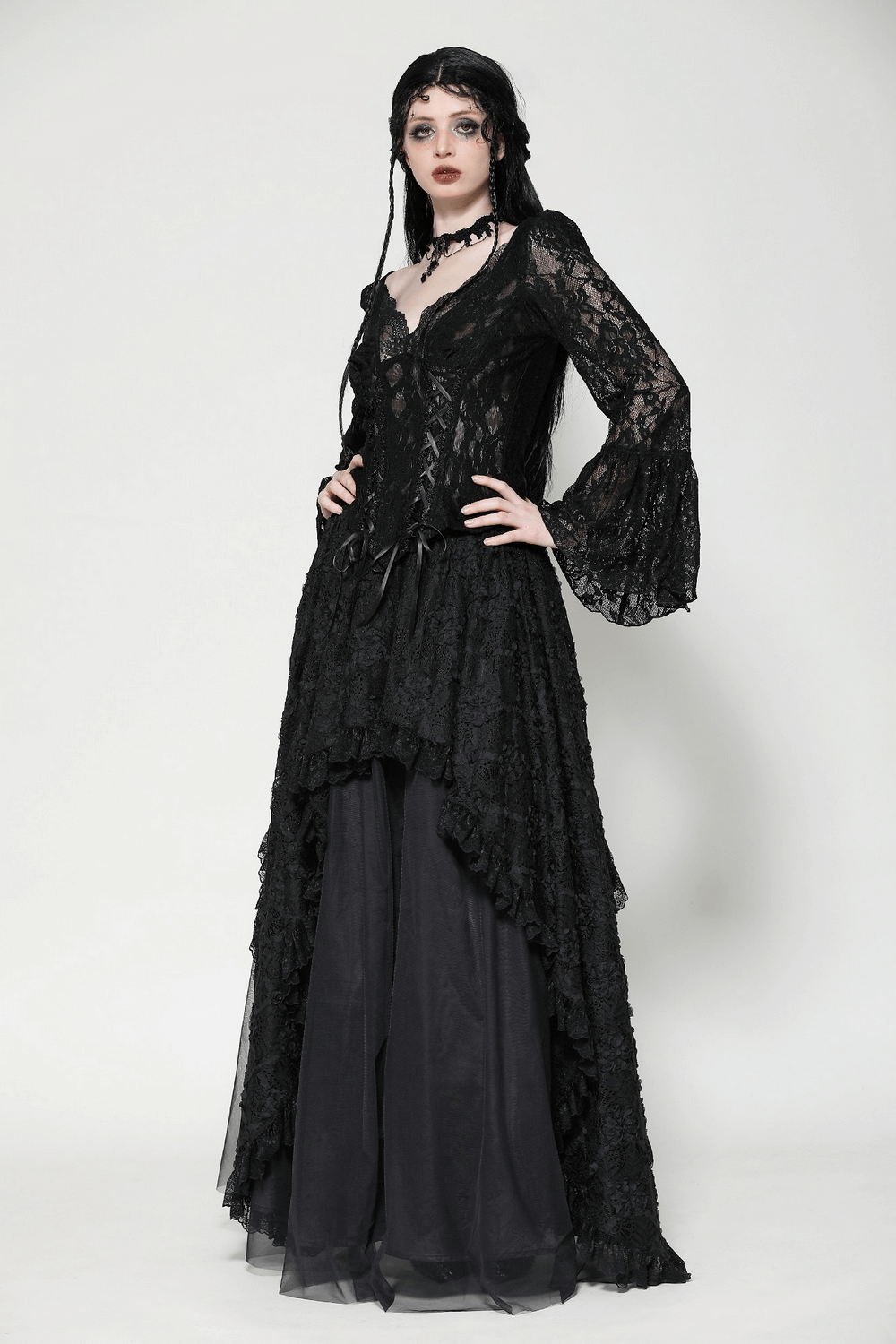 Elegant gothic model in black lace high-low maxi skirt with flowing layers and dramatic silhouette. Perfect for formal occasions.