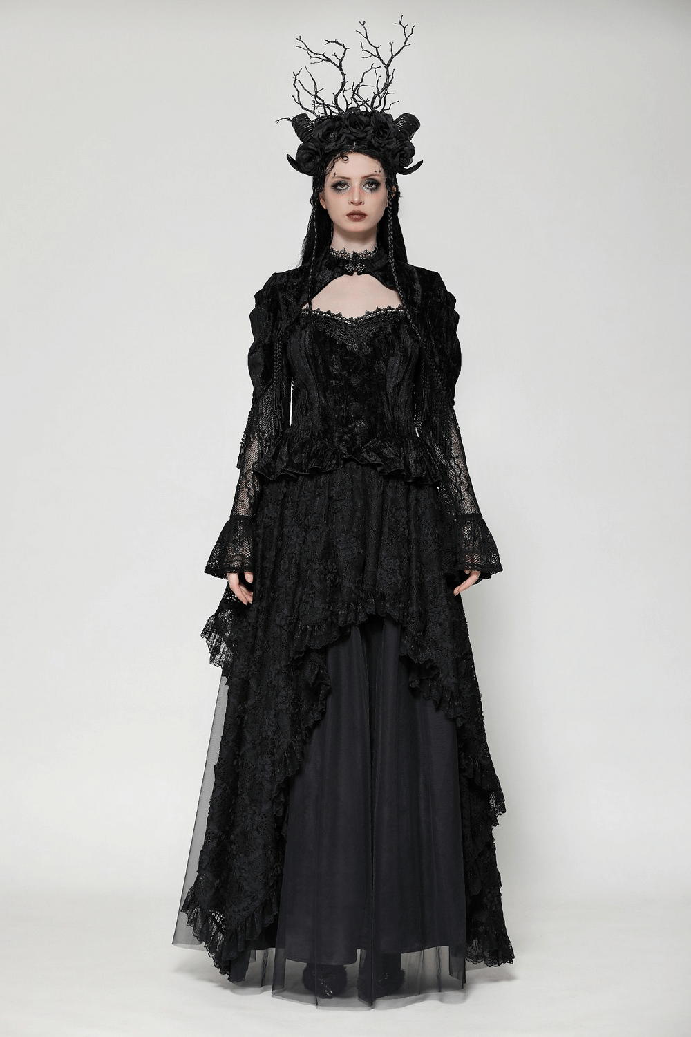 Elegant gothic woman in a dramatic black lace dress with an asymmetrical hem and striking crown, perfect for formal occasions.