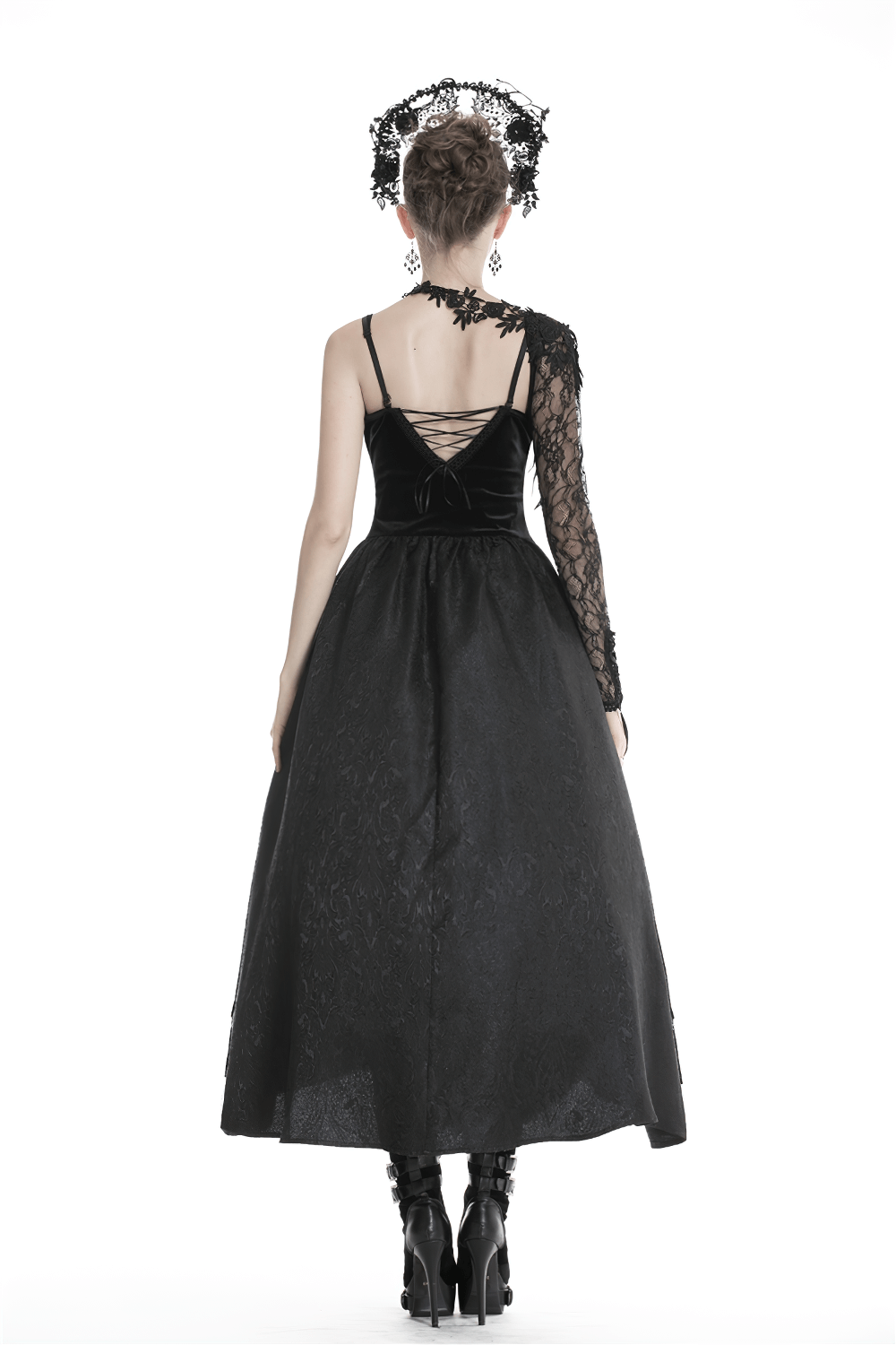 Back view of a model in a black elegant dress with a gothic lace sleeve accessory and floral appliques.