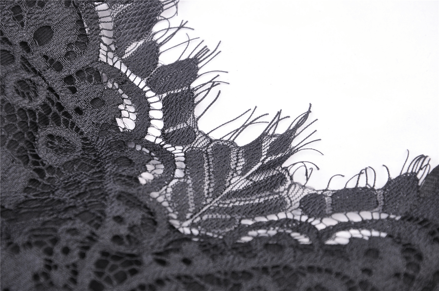 Close-up of delicate black lace trim showcasing intricate patterns and textures, perfect for elegant dresses.