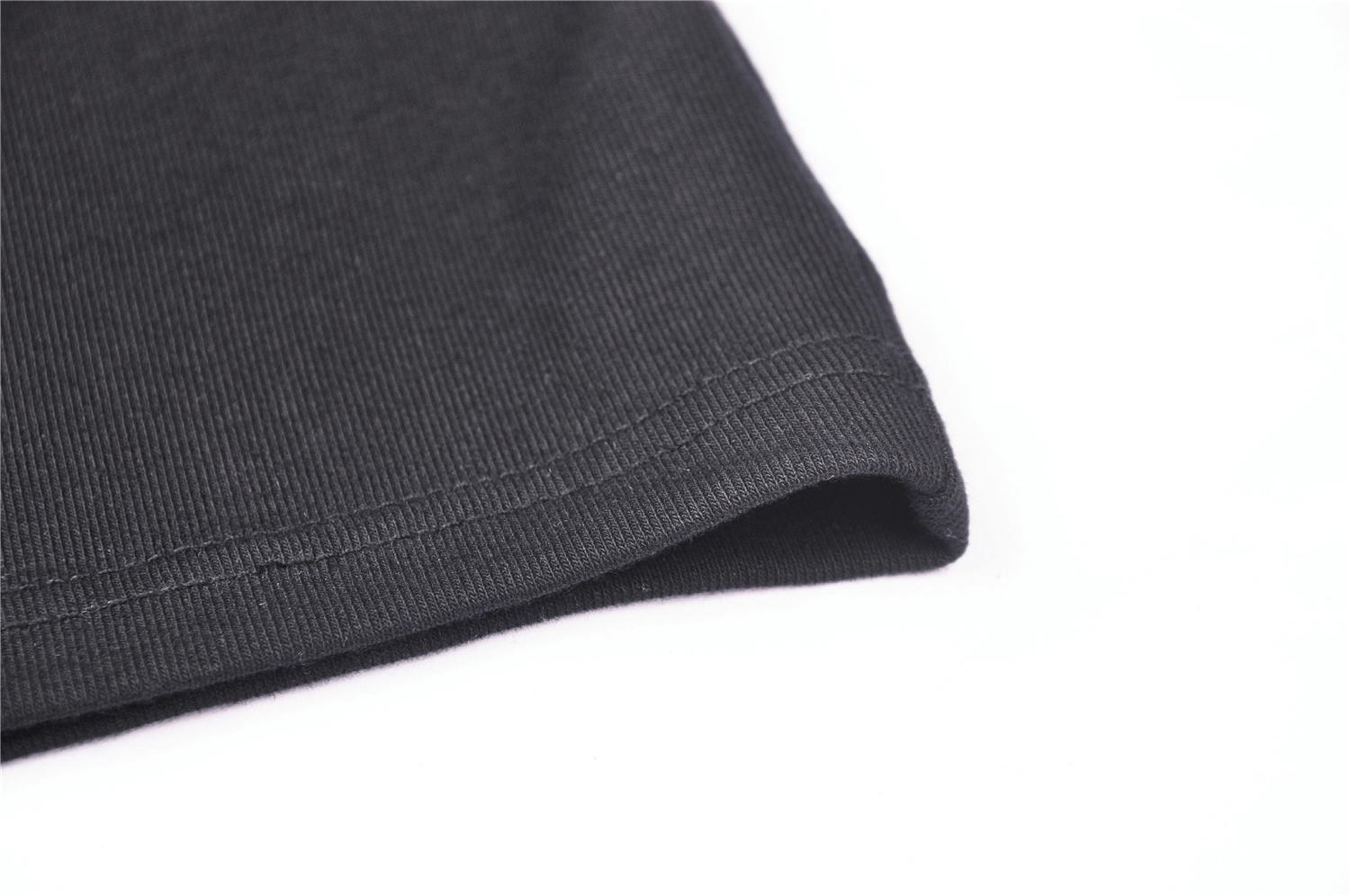 Close-up of sleek black fabric showcasing the hem detail, ideal for bodycon dresses or stylish apparel.