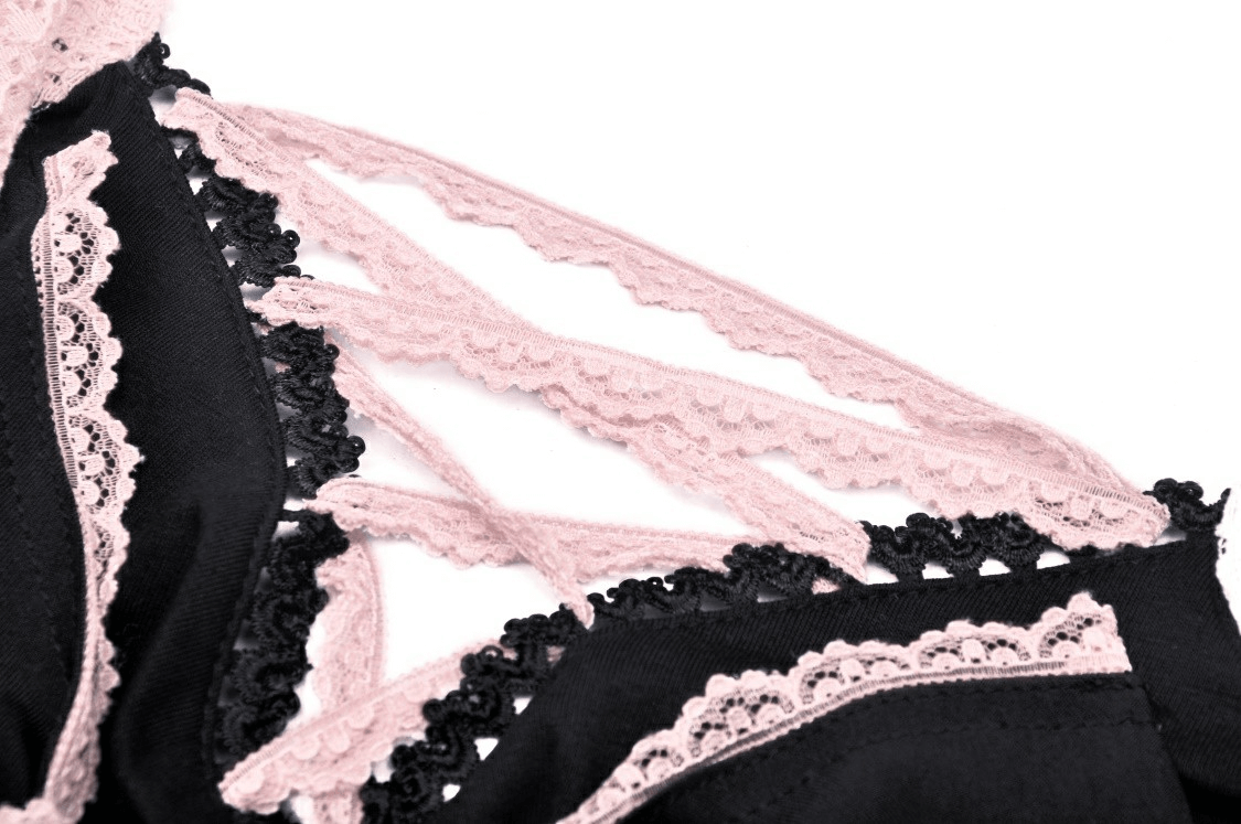 Close-up of black crop top with delicate pink lace trim and intricate bow detail, perfect for elegant evening wear.