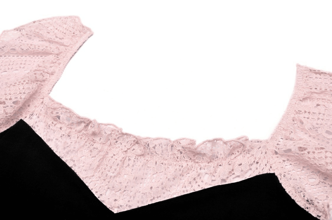 Close-up of elegant black crop top with pink lace trim and ruffled neckline, showcasing stylish design and feminine details.