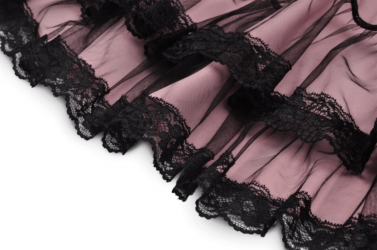 Elegant lace detail on ruffled hem of stylish gothic mini dress in soft pink and black accents.