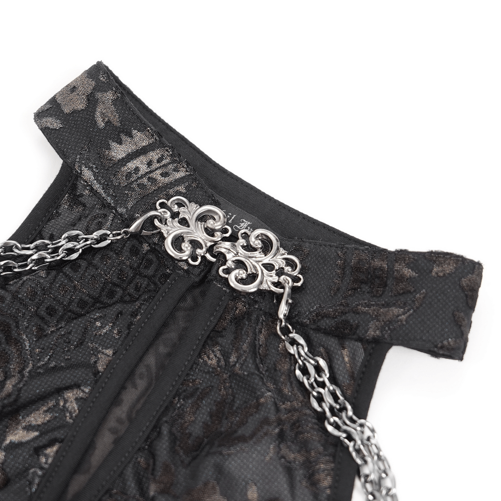 Close-up of elegant gothic lace dress detailing with floral embroidery and striking silver chain accents.