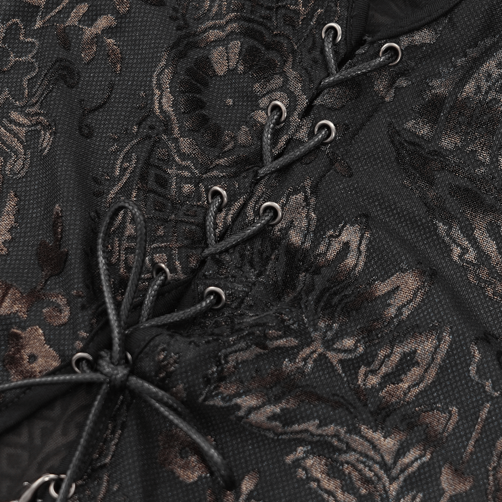 Close-up of elegant gothic lace dress featuring floral embroidery and chain detail on a dark mesh fabric.