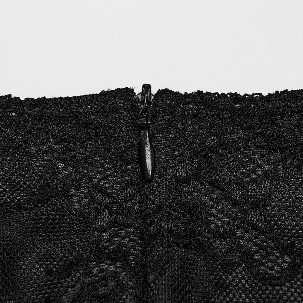 Close-up of the discreet zipper on an elegant black lace dress, showcasing intricate fabric detailing.