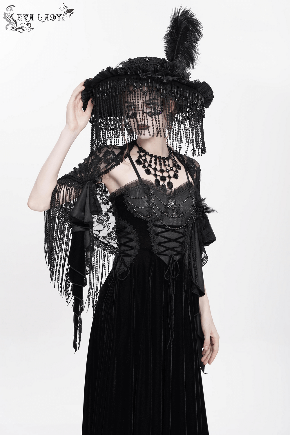 Chic model wearing an elegant black maxi dress with lace corset and intricate beaded detailing, showcasing gothic fashion.